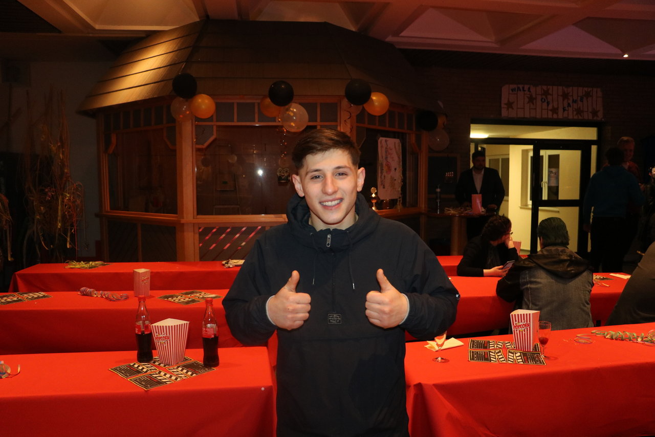 Ein Teilnehmer steht im gedeckten Freizeitraum und zeigt beide Daumen nach oben. Er lächelt in die Kamera.